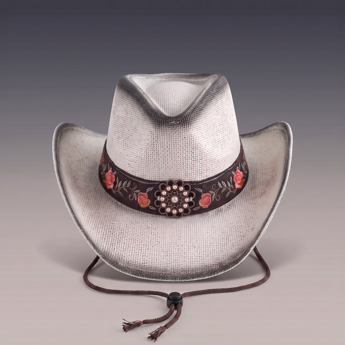 Chapeau de cowboy Rosalia en paille blanche patinée, bandeau brodé de roses et cordon de maintien, vu de face